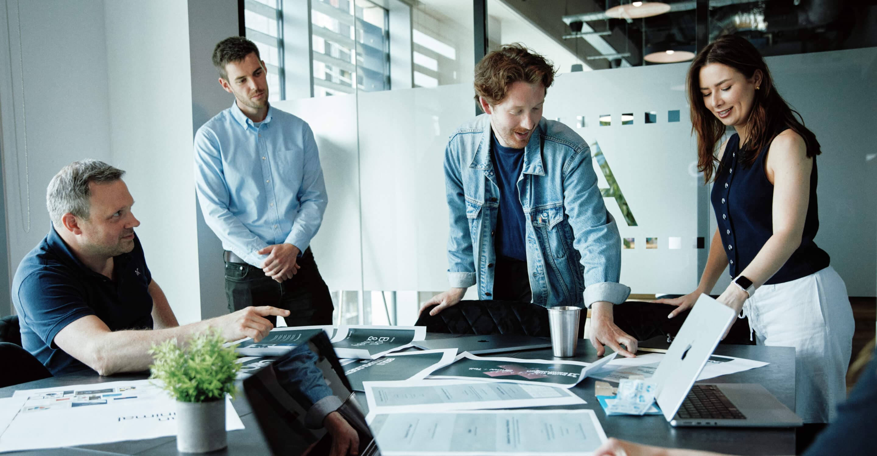 Colleagues engaged in a brainstorming workshop, surrounded by sketches, notes, and laptops.