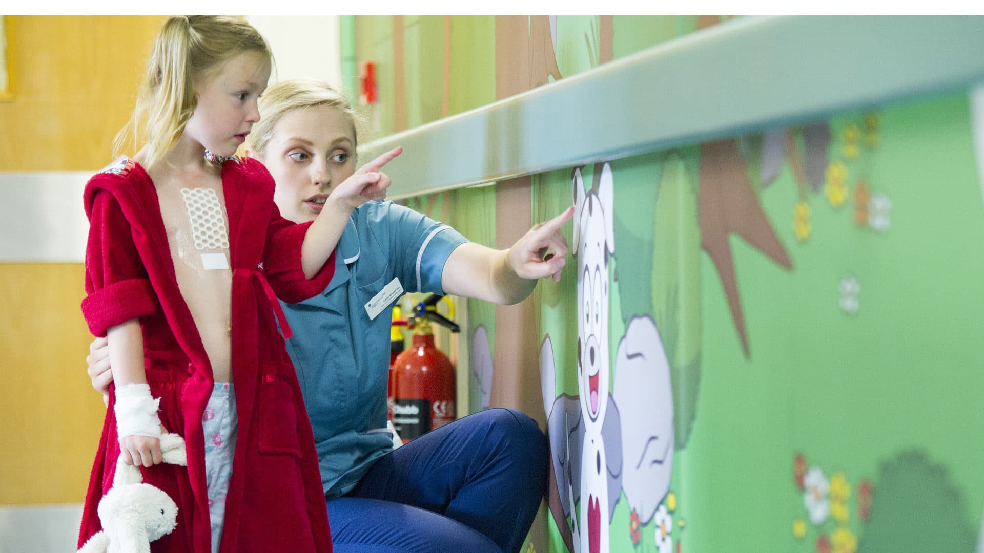 Woman and child in a hospital ward looking at art