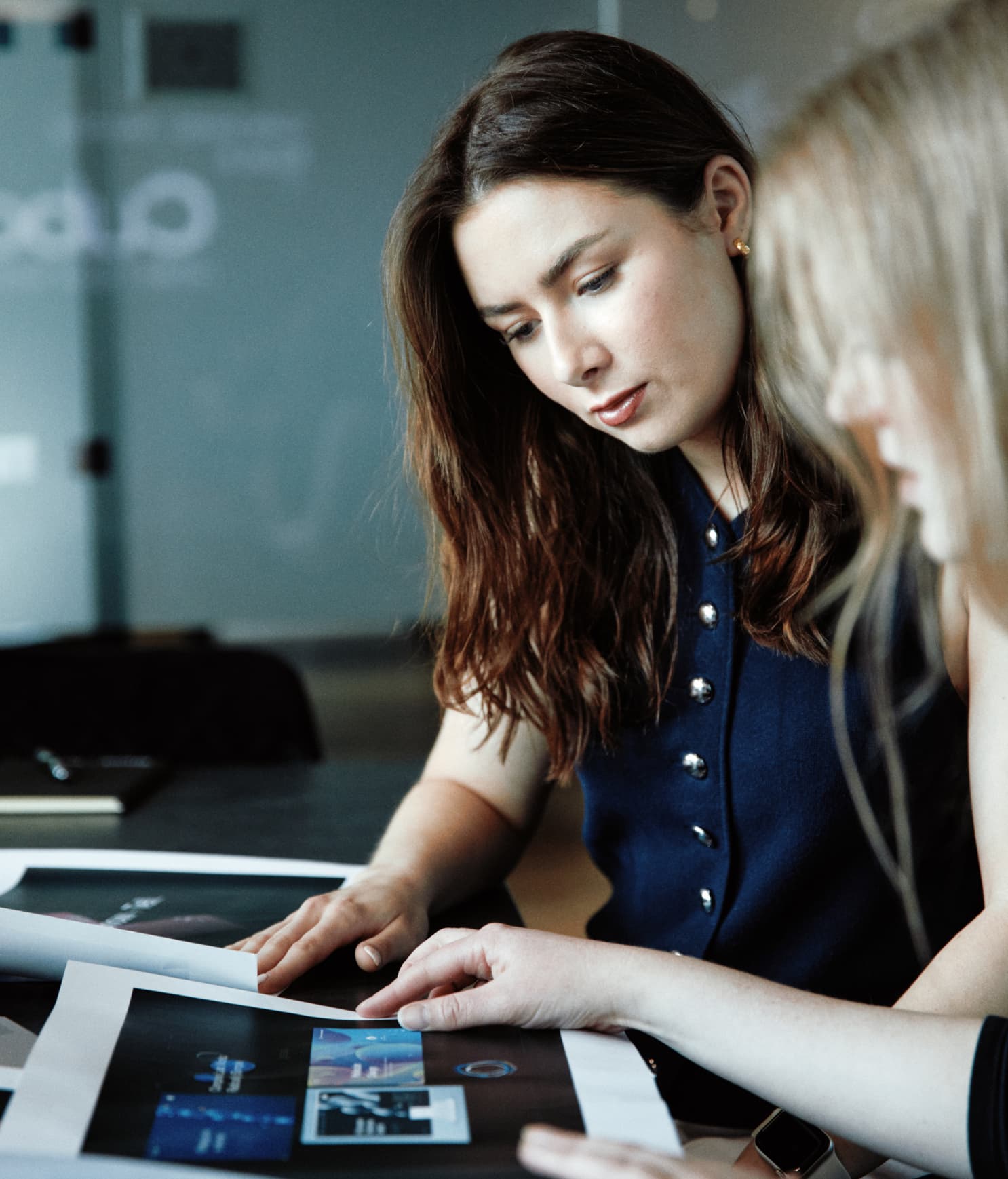 Two designers reviewing a selection of creative routes laid out on the table, thoughtfully discussing design directions.